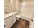 Well-lit bathroom with a white vanity featuring granite countertop, toilet, and a clean, white shower-tub combo at 606 E Carpenter St, Dallas, NC 28034