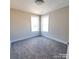 Bright bedroom featuring carpet flooring, neutral walls, white trim, and ample natural light from two windows at 606 E Carpenter St, Dallas, NC 28034
