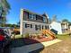 Inviting two-story home showcasing gray siding, black shutters, and an appealing entryway with wooden steps at 606 E Carpenter St, Dallas, NC 28034