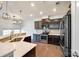 Well-appointed kitchen with stainless steel appliances, granite countertops, dark cabinets, and a view of the dining area at 609 Kahana River Rd, Fort Mill, SC 29715