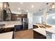 Modern kitchen featuring stainless steel appliances, granite countertops, and dark wood cabinets with an open layout to the living areas at 609 Kahana River Rd, Fort Mill, SC 29715
