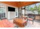 Relaxing covered back porch with comfortable seating, a ceiling fan, and an outdoor TV at 8013 Sheckler Ln, Matthews, NC 28104
