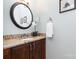 Well-lit half bathroom vanity with granite countertop, decorative mirror, and floral arrangement at 8013 Sheckler Ln, Matthews, NC 28104