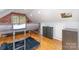 Well-lit bedroom with a metal bunk bed, hardwood floors, and a brick accent wall at 8013 Sheckler Ln, Matthews, NC 28104
