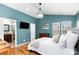 Well-lit main bedroom featuring wood floors, a king sized bed, and ensuite bathroom at 8013 Sheckler Ln, Matthews, NC 28104