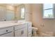 Bathroom features a white vanity with marble countertop, a window, and a toilet at Tbd Boomer Ct # 11, Statesville, NC 28677