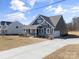Charming blue two-story home with stone accents, a covered porch, and a long driveway at Tbd Boomer Ct # 13, Statesville, NC 28677