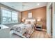 A bright bedroom with a patterned bedspread, large window, and a peach accent wall at Tbd Boomer Ct # 9, Statesville, NC 28677