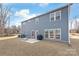 View of back exterior with large yard, windows, door, grill, and concrete patio extending from the home at 1043 Kalli Dr, Matthews, NC 28104