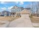 Charming two-story home with a combination of blue siding and brick, and an attached two-car garage at 1043 Kalli Dr, Matthews, NC 28104