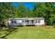 Well-maintained single-story home with charming front porch and wheelchair ramp access surrounded by lush trees at 1060 Sierra Rd, York, SC 29745