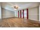 Bright, open living room with hardwood floors, ceiling fan, and large windows dressed with red drapes at 1060 Sierra Rd, York, SC 29745