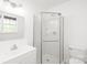 Bright bathroom with a glass-enclosed shower, vanity, and toilet against white walls at 111 Pine Grove Church Rd, Concord, NC 28025