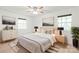 Neutral bedroom featuring a ceiling fan, bed with lamps, a dresser, and natural light at 111 Pine Grove Church Rd, Concord, NC 28025