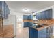 Bright kitchen with blue cabinets, an island cooktop, and durable countertops at 111 Pine Grove Church Rd, Concord, NC 28025