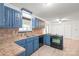 Well-lit kitchen with classic blue cabinets and stainless steel appliances for efficient cooking at 111 Pine Grove Church Rd, Concord, NC 28025