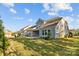 View of backyard featuring lush green grass and the home's exterior with neutral siding and an outdoor patio at 11227 Whimbrel Ct, Charlotte, NC 28278