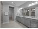 Sleek bathroom showcasing double vanity with framed mirrors and stone countertops at 11227 Whimbrel Ct, Charlotte, NC 28278