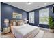 Well-lit primary bedroom with a white bed, blue walls, and bright windows at 11227 Whimbrel Ct, Charlotte, NC 28278