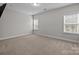 Well-lit bedroom featuring neutral carpet and two bright windows with views of the surrounding landscape at 11227 Whimbrel Ct, Charlotte, NC 28278