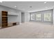 Spacious bonus room with neutral carpet, built-in shelving, and abundant natural light from three windows at 11227 Whimbrel Ct, Charlotte, NC 28278