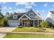 Beautiful home with a stone facade, manicured lawn, and attached two-car garage on a sunny day at 11227 Whimbrel Ct, Charlotte, NC 28278