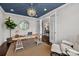 Bright home office featuring a stylish light fixture, wood desk, and white trim at 11227 Whimbrel Ct, Charlotte, NC 28278