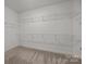 An Empty walk-in closet with carpeted floors and white metal shelving at 11227 Whimbrel Ct, Charlotte, NC 28278