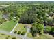 Property surrounded by mature trees, featuring a long driveway, and green grass at 1228 Swift Rd, Oakboro, NC 28129