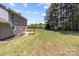 Expansive backyard view shows the spacious yard, deck, and mature trees with a clearing and fence line at 1228 Swift Rd, Oakboro, NC 28129