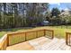 View from the deck to the spacious backyard featuring mature trees, a storage shed, and a trampoline at 1228 Swift Rd, Oakboro, NC 28129