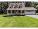 Home exterior showcasing a cozy front porch and well-maintained landscaping at 1228 Swift Rd, Oakboro, NC 28129