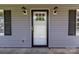 Exterior front door featuring a black door frame, wall lanterns, and window shutters at 1228 Swift Rd, Oakboro, NC 28129