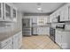 Updated kitchen with stainless steel appliances, white cabinets, and stylish tile backsplash at 1228 Swift Rd, Oakboro, NC 28129