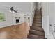 Open-concept room features hardwood floors, a brick fireplace, and stairs to the upper level at 1228 Swift Rd, Oakboro, NC 28129