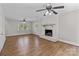 Open living area features a brick fireplace, hardwood floors, and many windows for natural light at 1228 Swift Rd, Oakboro, NC 28129