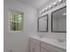 Bright bathroom featuring a double sink vanity, well-lit mirrors, and a window offering a view of the outdoors at 1241 Pitts Rd, Chester, SC 29706