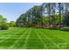 Extensive backyard lawn with meticulously striped patterns beneath a clear, blue sky at 125 Swayne Dr, Mooresville, NC 28117
