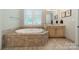Elegant bathroom featuring a soaking tub with decorative tile surround at 125 Swayne Dr, Mooresville, NC 28117
