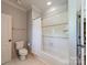 Neutral bathroom with white tile shower, toilet, and neutral walls at 125 Swayne Dr, Mooresville, NC 28117