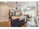 Open kitchen with island, stainless steel appliances, hardwood floors, and farmhouse sink at 125 Swayne Dr, Mooresville, NC 28117