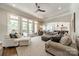 Open-concept living room featuring large windows, neutral colors, and a ceiling fan at 125 Swayne Dr, Mooresville, NC 28117