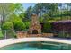 Outdoor fireplace and wood storage area on the edge of an outdoor pool at 125 Swayne Dr, Mooresville, NC 28117