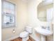 Cozy half-bathroom featuring a sink, toilet, and window with natural light at 126 Dairy Farm Rd, Mooresville, NC 28115