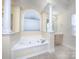 Luxury bathroom showcasing a soaking tub, decorative pillars, and an arched window at 126 Dairy Farm Rd, Mooresville, NC 28115