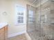 Modern bathroom with glass-enclosed shower, neutral tile, and sleek fixtures at 126 Dairy Farm Rd, Mooresville, NC 28115
