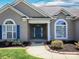 Inviting home entrance with blue door, brick accents, arched windows, and landscaped flowerbeds at 126 Dairy Farm Rd, Mooresville, NC 28115