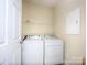 Functional laundry room with washer, dryer, and shelving for storage at 126 Dairy Farm Rd, Mooresville, NC 28115