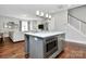Kitchen island with modern lighting, stainless steel microwave, and stylish gray cabinetry at 1416 S Church St, Charlotte, NC 28203