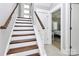 Modern staircase with wood treads, white risers, and a stylish handrail leading upstairs at 1416 S Church St, Charlotte, NC 28203